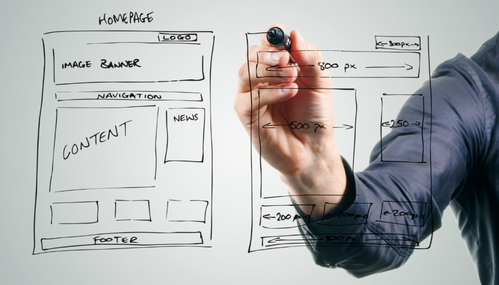 Hand drawing a custom website wireframe on a glass board, representing bespoke web design planning